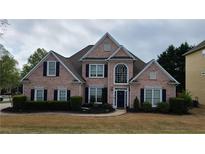 Beautiful brick home with a manicured lawn and dark shutters at 4118 Sandy Branch Dr, Buford, GA 30519