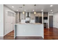 Modern kitchen featuring a large island, stainless steel appliances, and beautiful hardwood floors at 860 Peachtree Ne St # 1417, Atlanta, GA 30308