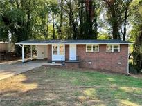 Charming brick home featuring a covered carport and well-manicured front lawn at 398 Windy Hill Se Rd, Marietta, GA 30060