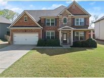 Charming two-story brick home with well-manicured lawn and a two-car garage at 4735 Belcrest Way, Cumming, GA 30040