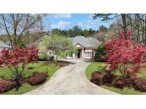Charming single-story home with well-manicured lawn and a long driveway leading to the front entrance at 2016 Westbourne Way, Johns Creek, GA 30022