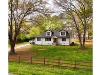 Charming two-story home featuring white siding, dormer windows, and a well-maintained front yard at 2638 Cleburne Pkwy, Powder Springs, GA 30127