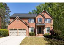 Charming two-story brick home with a two-car garage and manicured front yard at 3070 Jardin Nw Ln, Kennesaw, GA 30152