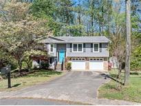 Charming split-level home with stone accents, two-car garage, and a bright blue front door at 1842 Jarrett Dr, Lawrenceville, GA 30043