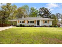 Charming one-story home with gray brick, wood shutters and landscaped yard at 974 Shirley Se St, Smyrna, GA 30082