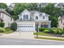 Charming two-story home featuring a two-car garage, well-manicured landscaping, and inviting curb appeal at 521 Mirramont Pl, Woodstock, GA 30189