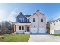 Charming two-story home with a two-car garage, covered porch, and beautifully manicured lawn in front at 288 Overlook Rd, Covington, GA 30014