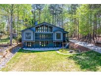 Striking home with large windows, a sprawling lawn, and a wooded backdrop at 1762 Green Rd, Buford, GA 30518