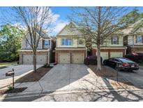 Charming townhome exterior features a two-car garage and inviting curb appeal with nice landscaping at 2840 Smith Ridge Trce, Peachtree Corners, GA 30071