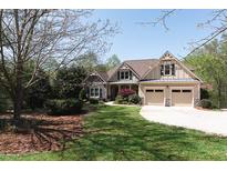 Charming two-story home featuring a stone facade, well-manicured lawn, and a two-car garage at 5095 Hamby Hollow Ln, Cumming, GA 30028