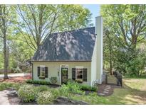 Charming home with a well-manicured lawn, lush landscaping, black shutters and a classic chimney at 1153 Haven Brook Ln, Brookhaven, GA 30319