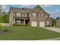 Charming two-story brick home featuring a well-manicured lawn and a two-car garage at 257 Ironwood Dr, Stockbridge, GA 30281