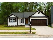Charming home featuring a well-manicured lawn, brick accents, and a two-car garage at 4907 Windsor Downs Dr, Decatur, GA 30035
