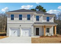 Two-story home featuring a white brick facade, a two-car garage, and a covered front porch with natural wood pillars at 342 Overlook Rd, Covington, GA 30014