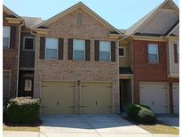 Townhome exterior boasts a brick facade, two-car garage, and well-maintained landscaping at 2162 Oakland Grove Pl, Lawrenceville, GA 30044