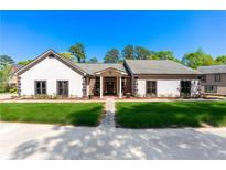 Charming single-story home with white stucco, manicured lawn, and inviting entrance at 2320 Copper Trail Ln, Buford, GA 30519