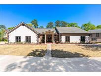 Inviting one-story home with a symmetrical facade, manicured landscaping, and a welcoming front porch at 2320 Copper Trail Ln, Buford, GA 30519