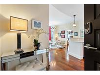 Inviting entryway featuring a mirrored console table, elegant lamp, fresh flowers, and a glimpse into the stylishly decorated living area at 1080 Peachtree Ne St # 3213, Atlanta, GA 30309