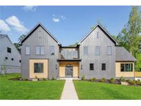 Beautiful modern home with a gray exterior, manicured lawn and symmetrical design on a sunny day at 115 Nova Ln, Roswell, GA 30075