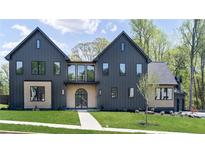 Stunning modern home with dark siding, complemented by well-manicured lawn and beautiful architectural details at 115 Nova Ln, Roswell, GA 30075