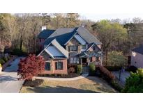 Charming two-story brick home with stone accents, mature trees, and a landscaped front yard at 610 Big Bend Trl, Sugar Hill, GA 30518