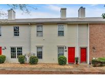 Charming townhome featuring a red front door, neutral siding, and well-maintained landscaping at 992 Old Holcomb Bridge Rd, Roswell, GA 30076