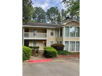 Inviting two-story condo with a balcony, landscaped entrance, and ample parking space at 1504 Augusta Se Dr, Marietta, GA 30067