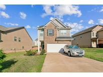 Charming two-story home features brick and siding, a well-maintained lawn, and an attached two-car garage at 2142 Theberton Trl, Locust Grove, GA 30248