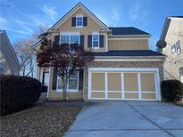 Two-story home with stone accents and a two-car garage, complemented by a well-maintained yard and mature landscaping at 445 Pintail Ct, Suwanee, GA 30024