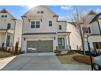 Beautiful two-story home featuring a gray two car garage and complementary landscaping at 627 Skytop Dr, Cumming, GA 30040