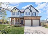 Charming two-story home with a manicured lawn, stone accents, and a two-car garage at 2625 Cross Springs Dr, Cumming, GA 30041