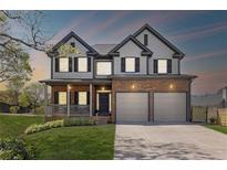 Charming two-story home showcasing a two-car garage, inviting porch, and manicured lawn at 2625 Cross Springs Dr, Cumming, GA 30041