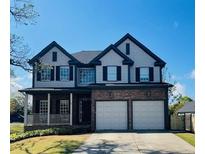 Charming two-story home featuring an attached two-car garage, covered front porch, and beautifully maintained lawn at 2625 Cross Springs Dr, Cumming, GA 30041