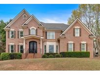 Elegant brick home featuring a symmetrical facade, detailed shutters, and manicured landscaping at 850 Highland Bend Cv, Alpharetta, GA 30022