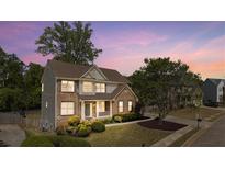 Charming two-story brick home featuring a well-manicured lawn and inviting front porch with beautiful landscaping at 826 Buffington Way, Canton, GA 30115