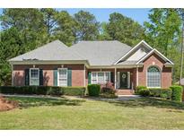 Charming single-story brick home featuring a well-manicured lawn and mature landscaping at 2545 Amberbrook Ln, Grayson, GA 30017