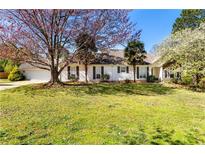 Charming one story home with a well-manicured lawn, mature trees, and inviting curb appeal at 65 Woodside Ct, Mcdonough, GA 30253