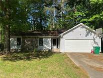 Charming single-story home with a stone facade, attached garage, and lush green lawn at 1228 Reilly Ln, Clarkston, GA 30021