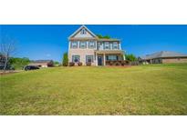 Charming two-story home with a well-manicured lawn and traditional architectural details at 10 Edgewater Ct, Covington, GA 30016