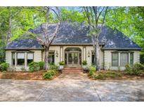 Charming home featuring a symmetrically designed exterior with a gray roof and beautiful front yard landscaping at 305 Heards Ferry Rd, Atlanta, GA 30328