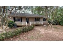 Charming single-story home featuring a cozy front porch nestled among mature trees at 99 Fox Ridge Ct, Dallas, GA 30157