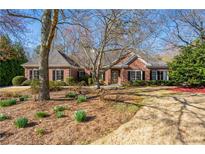 Charming single-story brick home with a well-manicured lawn and mature trees, offering classic curb appeal at 4185 Waterford Dr, Suwanee, GA 30024