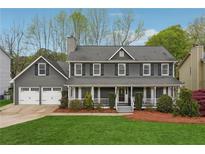 Charming two-story home with a welcoming front porch and well-manicured lawn and a two car garage at 2597 Oak Village Ne Pl, Marietta, GA 30062