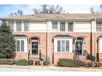 Charming townhome featuring a classic brick facade, black awnings, and well-maintained landscaping at 7 Chief Matthews Rd # 2A, Decatur, GA 30030