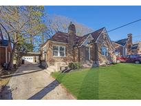 Charming brick home featuring a manicured lawn, covered parking, and classic architectural details at 1395 Winburn Dr, East Point, GA 30344