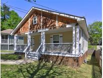Charming home with a inviting front porch, decorative railings, and attractive cedar shingle detail at 2264 Pryor Rd, Atlanta, GA 30315
