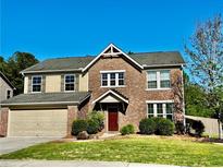 Inviting two-story brick home featuring a well-manicured lawn and attached two-car garage at 2499 Sinclair Trce, Powder Springs, GA 30127