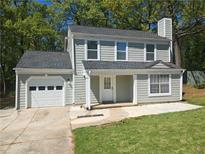 Charming two-story home with light green siding, a well-manicured lawn, and attached garage for modern living at 1276 Seattle Slew Ln, Norcross, GA 30093