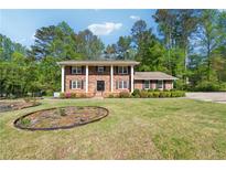 Beautiful brick home with a large front yard and mature trees at 244 Saint Patrick Sw Dr, Mableton, GA 30126