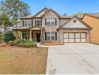 Charming two-story home with brick accents, a two-car garage, and a well-manicured front yard at 3541 Stoneleigh Walk, Lithonia, GA 30038